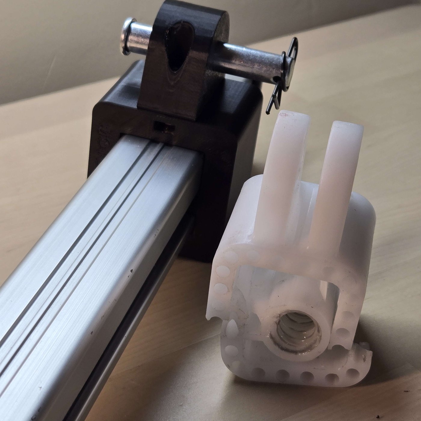 A 3D-printed replacement block installed on a recliner actuator, next to the broken original